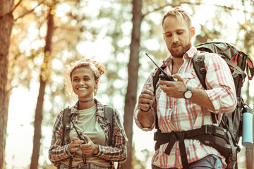 Delighted cheerful couple using special walkie talkies