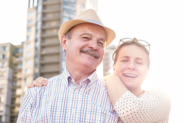 Portrait of a happy mature man smiling with young woman. Hispanic father in summer hat and daughter walking outdoor together. Father day concept. Being together with parents.