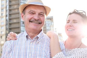 Portrait of a happy mature man smiling with young woman. Hispanic father in summer hat and daughter walking outdoor together. Father day concept. Being together with parents.