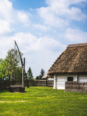 Old wooden house and a well in the countryside