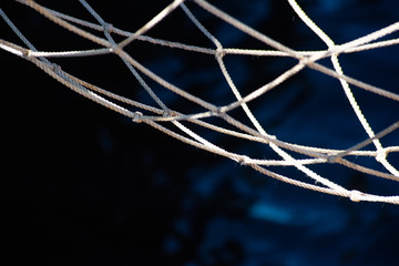 Fishing net and blue dark water surface, soft focus