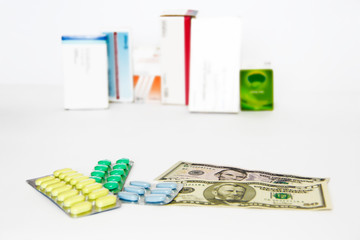 yellow green blue medical pills and american dollars on white background
