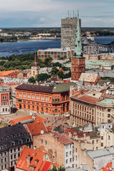 Obraz premium Red roofs of old Riga. Riga cityscape on a sunny summer day. City aerial view of the old town with the Dome Cathedral and the Daugava River in the city of Riga, Latvia