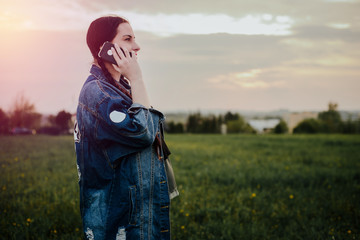 Pregnant woman talking on the phone. The concept of being pregnant, the future mother enjoys the period of being pregnant. Communication and telephone conversation.