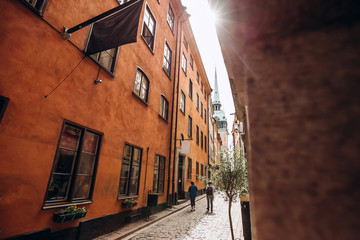 Narrow street of the old town. Gamla Stan, the oldest part of Stockholm, Sweden. Scandinavia, Northern Europe. Architectural landmark of Stockholm. Sunny weather with blue sky