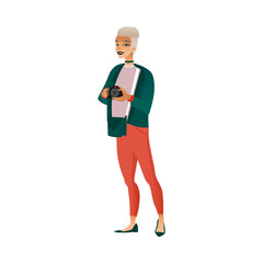 Young woman with short white hair in red pants and green jacket with a camera in hand.