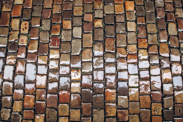 cobblestone road, texture photographed from above. Stone pavement texture gray and brown color, wet pavement. top view close up