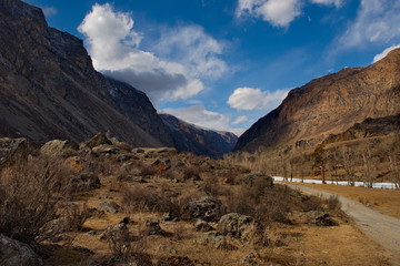Russia. Mountain Altai. Dirt road in the valley of the river Chulyshman.
