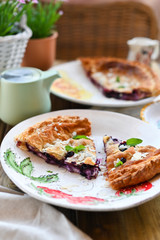 Homemade cake with puff pastry. Summer homemade pastries for a family breakfast. Photo in a rustic style of life. Portions for food on the table. Ceramic dishes beautiful. Copy space.