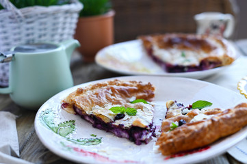 Homemade cake with puff pastry. Summer homemade pastries for a family breakfast. Photo in a rustic style of life. Portions for food on the table. Ceramic dishes beautiful. Copy space.