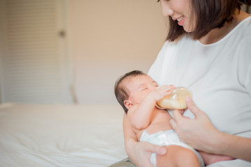 Newborn baby girl is drinking milk by  her mother