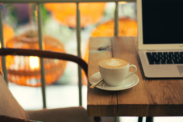 Warm light of lamps and cup of coffee on the cafe table