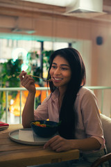 Cheerful lady enjoying her meal and smiling wheil eating