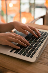 Woman using her laptop and putting hands on the keyboard