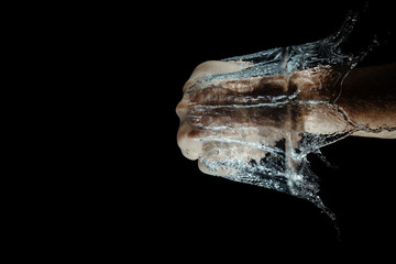 A hand hits the water while making a splash isolated on a dark background. Top view of a strong...