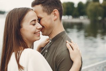 Cute couple in a city. Lady in a white dress. Boy in a green shirt