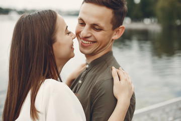 Cute couple in a city. Lady in a white dress. Boy in a green shirt