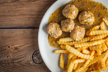 Meatballs with french fries in dill sauce.