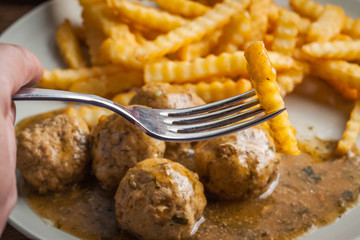 Meatballs with french fries in dill sauce.