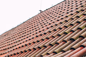 Exterior of brick house with red roof tiles, Prague. Retro red tile roof of old house