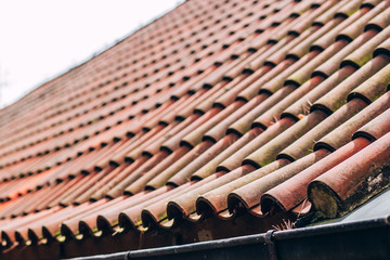 Exterior of brick house with red roof tiles, Prague. Retro red tile roof of old house