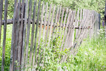 old shaky wooden picket fence closeup view on outdoor nature background