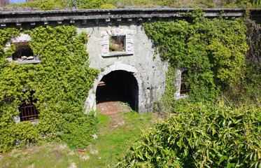 scary access portal, arched to enter the Fort Bastion of Fosdinovo, a fortress taken by nature and wild vegetation
