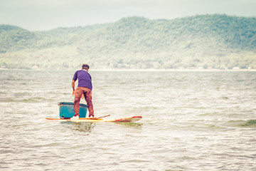 Fisherman of lake in action when fishing on twilight, Thailand.