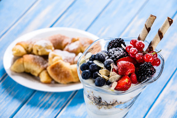 Yogurt with fruits on wooden background