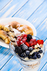 Yogurt with fruits on wooden background