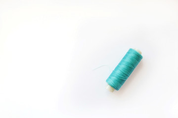 Multicolored thread coils on pink blue background. Sewing supplies and accessories for needlework,...