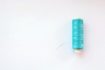 Multicolored thread coils on pink blue background. Sewing supplies and accessories for needlework, stitching, embroidery. space for text. flat lay, top view 