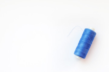 Multicolored thread coils on pink blue background. Sewing supplies and accessories for needlework, stitching, embroidery. space for text. flat lay, top view 