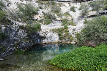 Lago de agua azul y cristalina entre montañas de caliza.