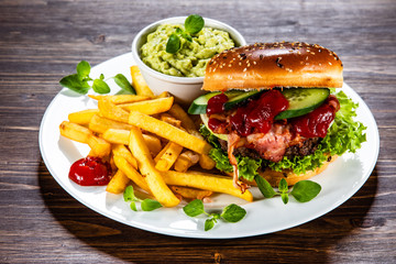Tasty burger with chips served white plate