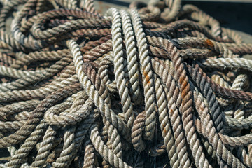 Fototapeta na wymiar Thick rope in the web and rust. Anchor halyard. Old dirty rope