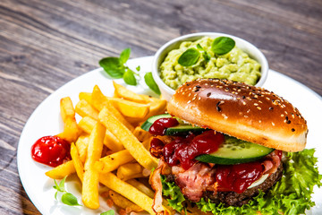 Tasty burger with chips served white plate