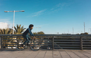 Man with afro hair riding a vintage style bicycle