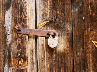 Old lock on the door. lock on the door of an old rural home. Real country style. close-up. focus on the castle. Old antique lock on old wooden doors in need of repair or replacement.