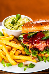 Tasty burger with chips served white plate