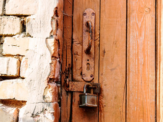 Old lock on the door. lock on the door of an old rural home. Real country style. close-up. focus on the castle. Old antique lock on old wooden doors in need of repair or replacement.