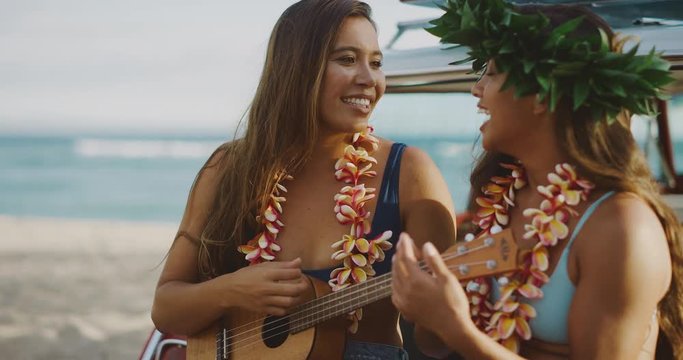 Portrait of beautiful young women singing smiling and playing the ukulele, sitting in a vintage beach cruiser car at sunset, happy laughing women wearing flower leis, hawaiian island cruising