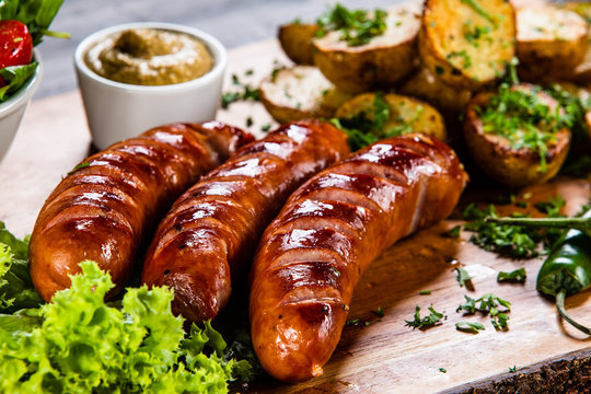 Grilled sausages and vegetables on cutting board