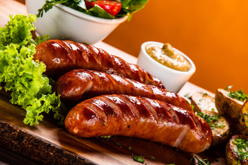 Grilled sausages and vegetables on cutting board