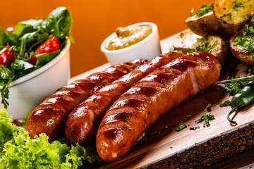 Grilled sausages and vegetables on cutting board