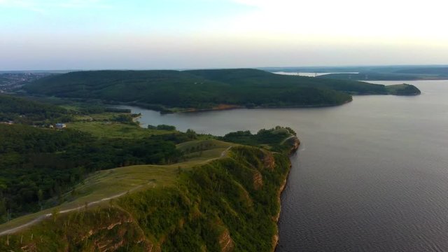 Aerial view of Zhiguli mountains with green trees and Volga river in Samarskaya Luka national park during summer evening, Samara region, Russia