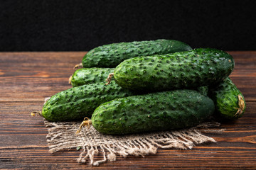 Fresh cucumbers on dark wooden background