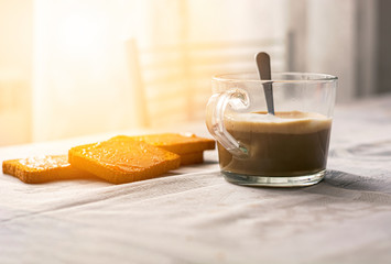 group of biscuits with jam spread with a cup of cappuccino on a table with the decorated tablecloth