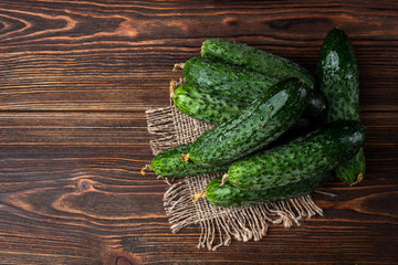 Fresh cucumbers on dark wooden background