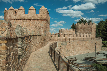 Pathway over old thick wall with large towers in Avila